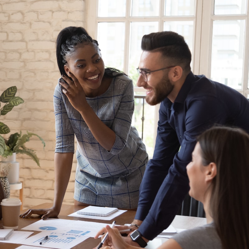 Workers at a conference table looking at charts