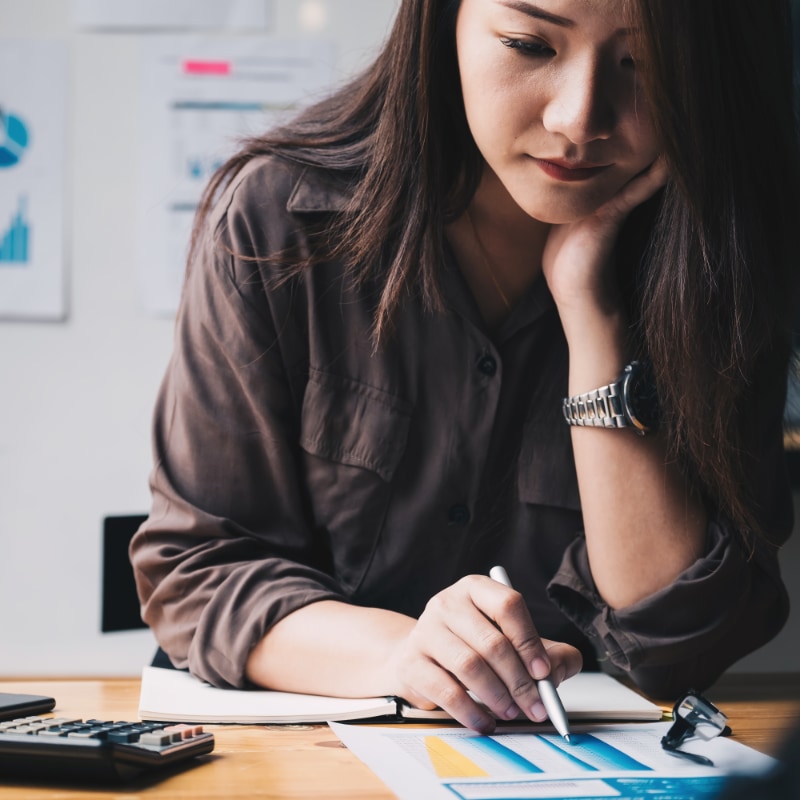 A woman sitting at a desk reading a chart